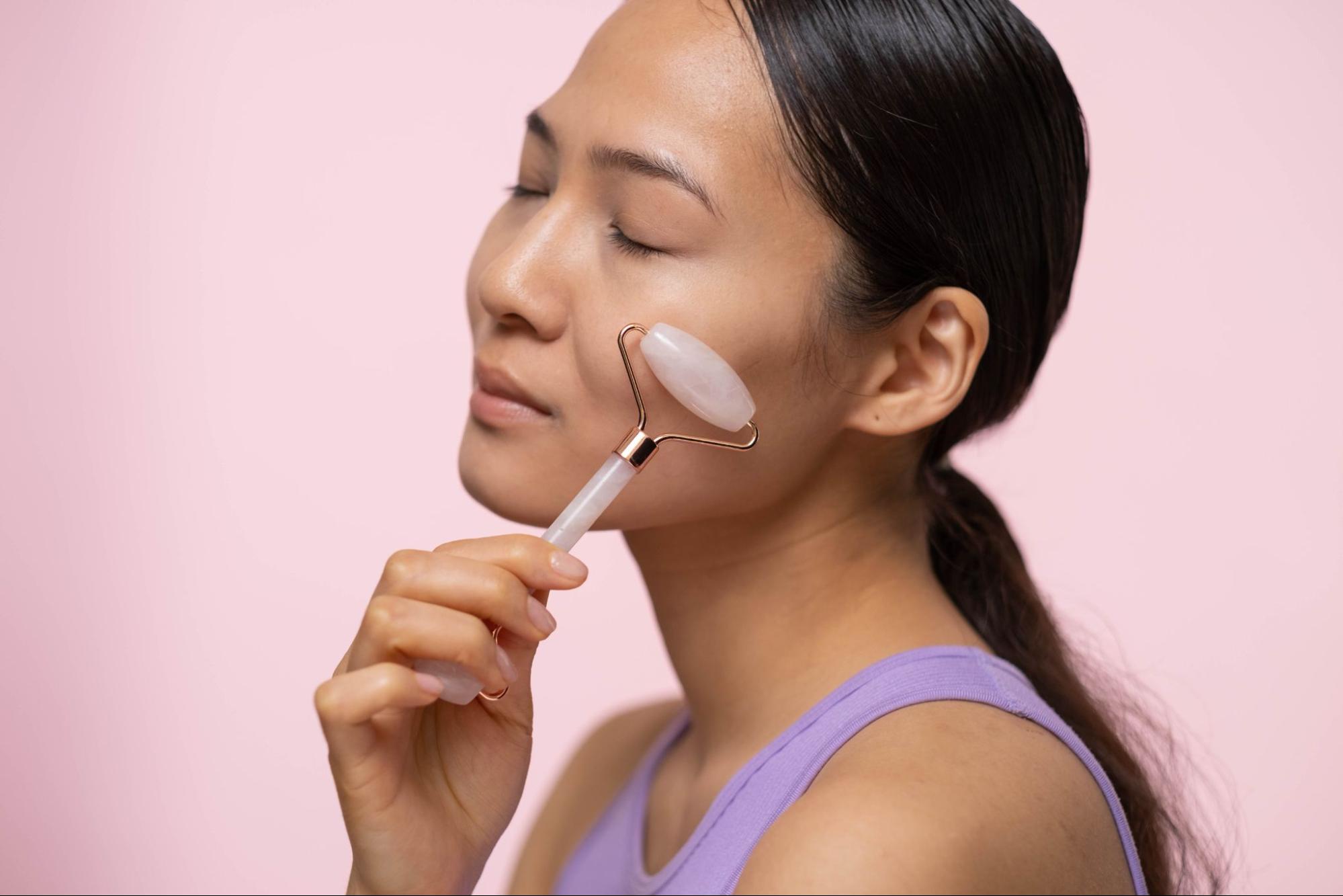 Woman using facial roller after face yoga