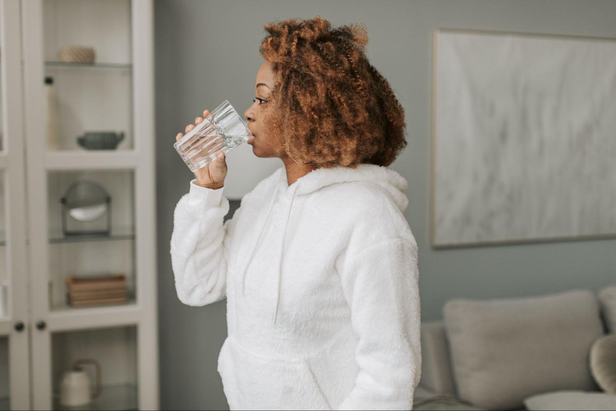 Woman drinking water as one of many gut health hacks